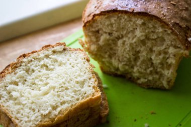 Masada dilimlenmiş ekmek. Yeşil tahtada ekmek.