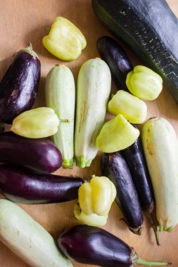 Sebze kompozisyonu masanın üzerinde. Biber, patlıcan, kabak. Sebze geçmişi. Boşluğu kopyala, üst görünüm