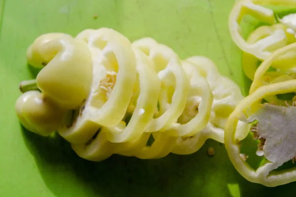 Sliced yellow peppers on a green board. Sliced pepper on the table. Culinary background. The process of cooking food in the kitchen.