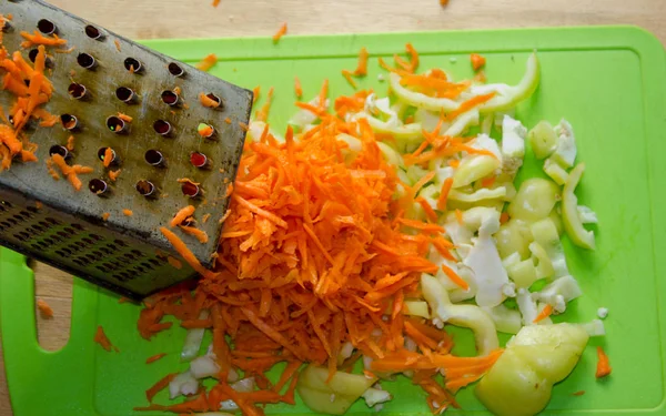 Zanahorias Ralladas Rallador Con Pimienta Picada Sobre Fondo Verde Con Imagen de stock