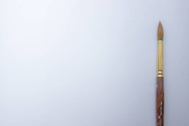 Beyaz arka planda boya fırçası. Fırçalı beyaz arka plan. Sanatsal malzemeler. boşluğu kopyala, üst görünüm, düz uzanma, metin için boş alan ile arkaplan