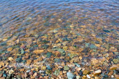 Deniz kıyısındaki renkli taşlar suyun altında. Tasarım için manzara.