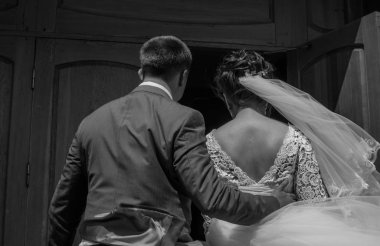 Damat gelini belinden tutar. Arka plan.