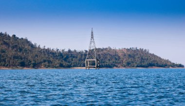 Electric tower on the lake, Silvassa, India clipart
