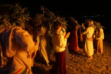 Çelenkli kızlar Ivan Kupal 'ın tatilinin etrafında dans ediyorlar. Yaşayan putperest geleneği.