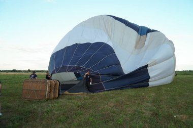 Çimlerin üzerinde yanan havayla uzanan bir balonu şişirmek. Topun içinde yanan bir ateş. Dniepro. Ukrayna.