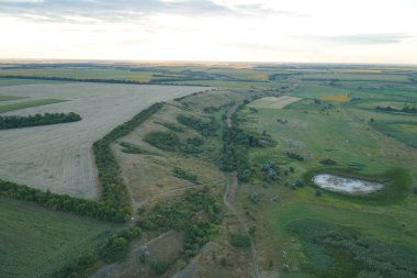 Ukrayna bozkırlarının çayırlarının ve tarlalarının en üst manzarası. Gün batımı gökyüzü.