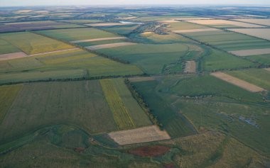Tarlaların ve bahçelerin manzarası yukarıdan. Gün batımı gökyüzü.