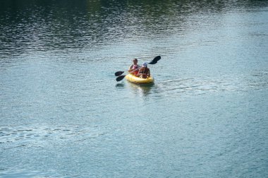                                People are brought to a kayak in the middle of a lake        
