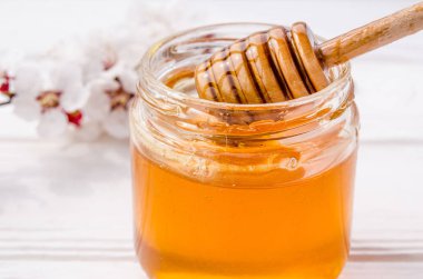 Taze altın kumu dolu bir cam kavanoz içinde bir tahta bal kaşığı