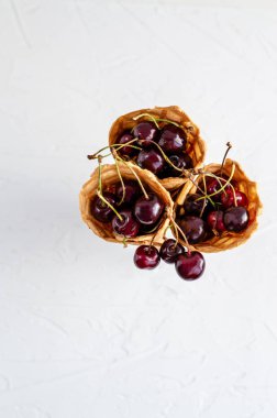 Üç dondurma konileri bir cam beher kiraz ile dolu 