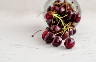 Olgun taze kırmızı tatlı kiraz ters cam bardak dökülür