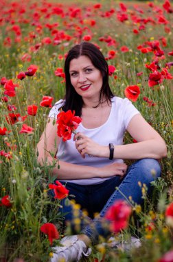 beyaz bir t-shirt ve mavi jea giyen koyu saçlı genç bir kız