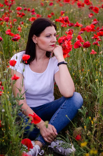 A young girl with dark hair is wearing a white T-shirt and blue — Stock Photo, Image