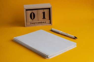 Eylül tarihi ile defter, beyaz kalem, ahşap takvim 