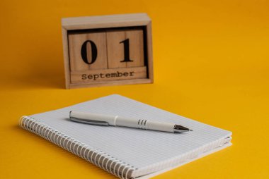 Eylül tarihi ile defter, beyaz kalem, ahşap takvim 