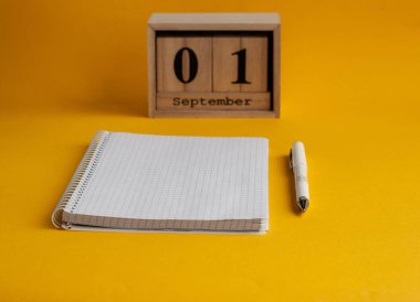 Eylül tarihi ile defter, beyaz kalem, ahşap takvim 