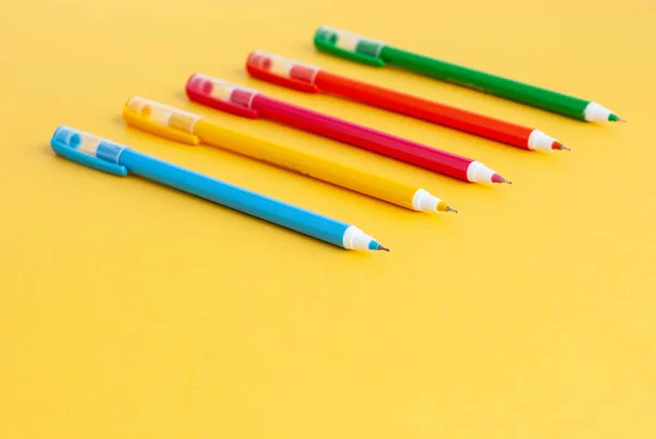 Цветные ручки, аксессуары для учебы на желтом фоне . — стоковое фото