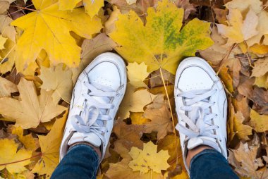 Kadın beyaz spor ayakkabıları yerde duruyor