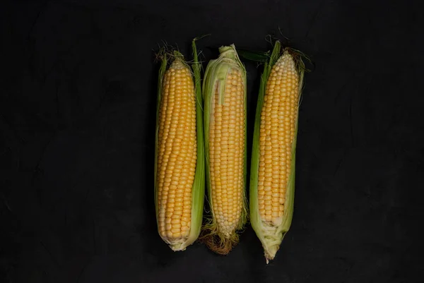 Yellow sweet raw corn on a black background. — Stock Photo, Image