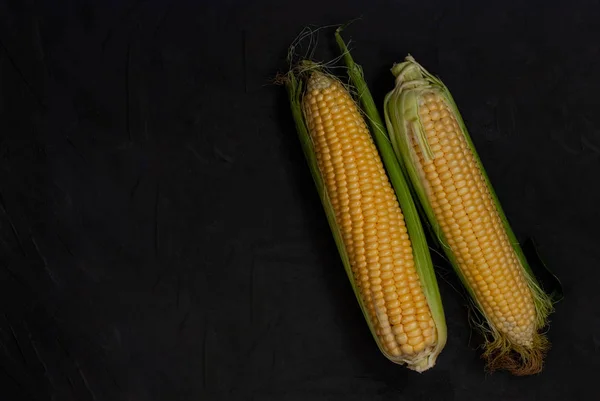 Yellow sweet raw corn on a black background. — Stock Photo, Image