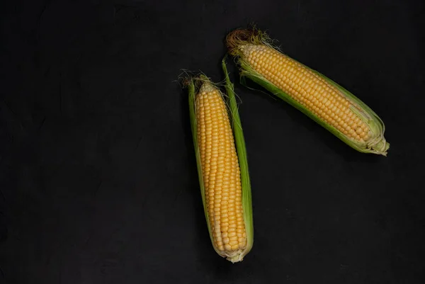 Yellow sweet raw corn on a black background. — Stock Photo, Image