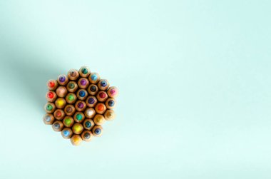 Renkli kalemler mavi arka planda bir grupta duruyor. Çizim, yaratıcılık, hobiler, dersler için bir dizi kalem. Düz konum, kopyalama alanı, metin için boşluk. Yukarıdan görüntüle