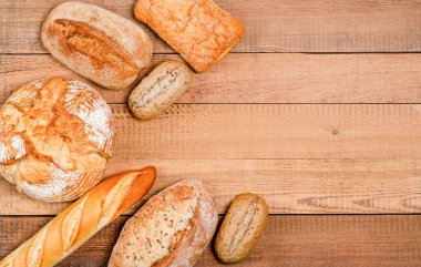 Fırın - çeşitli rustik gevrek somunlar ve tahta tahtalar üzerinde rulo ekmek. Boşluğu, düzlüğü, metin için yeri kopyala. Yukarıdan görüntüle.