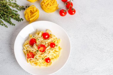 Domatesli ev yapımı fettucine makarna, kekik, beyaz bir tabakta parmesan peyniri. Geleneksel İtalyan yemeği. Uzayı kopyala, düz yat. Düzgün beslenme, diyet. Yukarıdan görüntüle