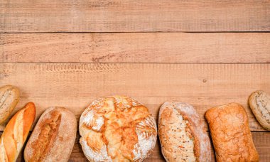 Fırın - çeşitli rustik gevrek somunlar ve tahta tahtalar üzerinde rulo ekmek. Boşluğu, düzlüğü, metin için yeri kopyala. Yukarıdan görüntüle.