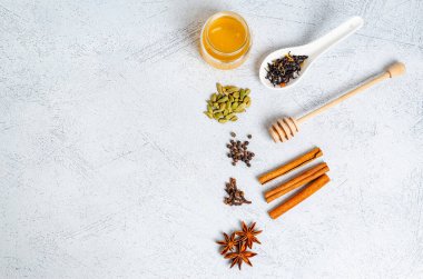 Hint geleneksel masala çayı içeceği yapmak için gerekli malzemeler. Tarçın, kakule, anason, bal, karanfil, arka planda kuru çay. Yukarıdan bak. Metin için boşluk kopyala, düz yatay.