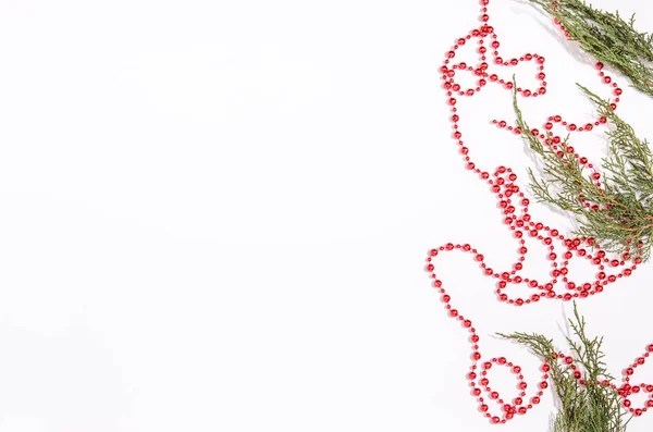 크리스마스 장식용 주니퍼와 붉은 구슬로 만든 녹색 가지들과, 흰색 배경에 평평 한 면이 있는 복사 공간이 있는 곳. — 스톡 사진
