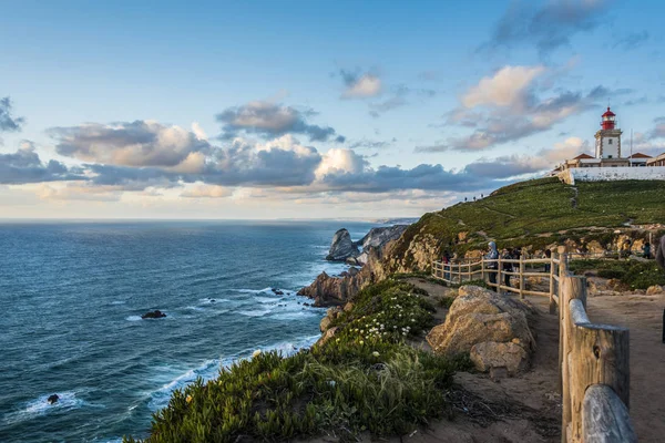 Gün batımında deniz feneri ile Cabo da Roca'nın kuzeyindeki Atlantik kıyısı
