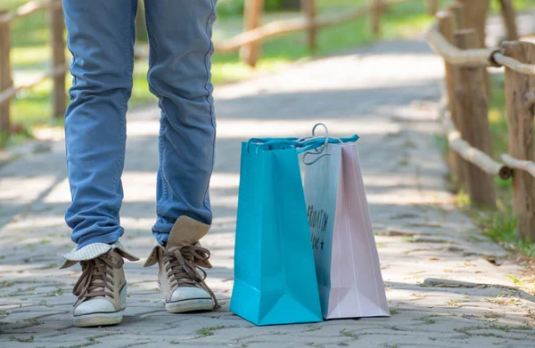 Alışveriş yaptıktan sonra kot pantolon ve spor ayakkabı giyen kadınlar.