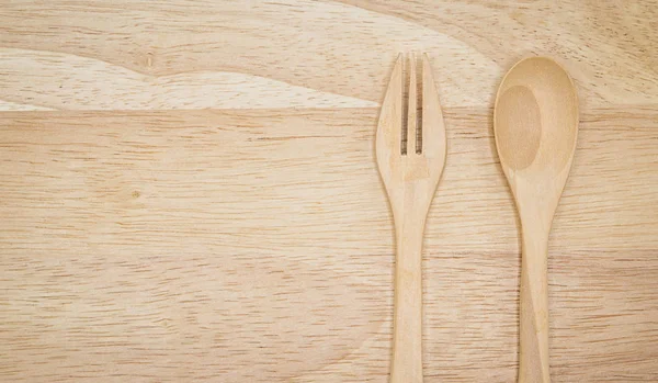 One pair of spoons and forks made of wood, placed on large woode