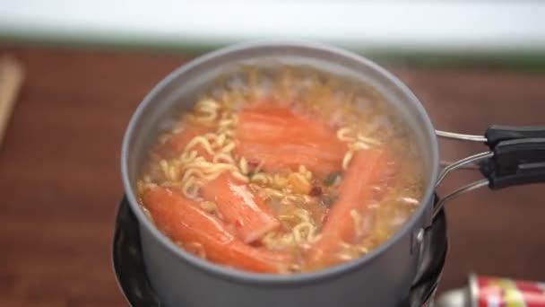 Faire bouillir les nouilles instantanées avec de l'eau bouillante et ajouter des bâtonnets de crabe ainsi. — Video