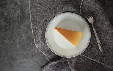 Peynirli kekin üst görüntüsü, beyaz bir tabağa yerleştirilmiş..