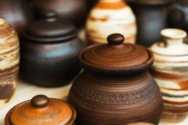 Bir sürü fuarda seramik yemekleri. Kil Ulusal Rus yemekleri. Yanmış siyah seramik. Yanmış kil tencere ve kaplamalar, yemekler