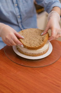 Pasta şefi pasta katının bir kek üzerine koyar.