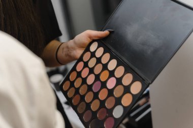 makyaj sanatçısı elinde gölgeler bir paleti. Kız gölgeler boya