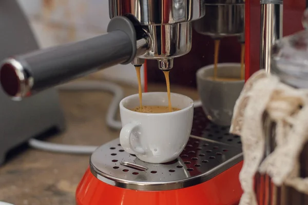 coffee maker pours coffee into the cup.