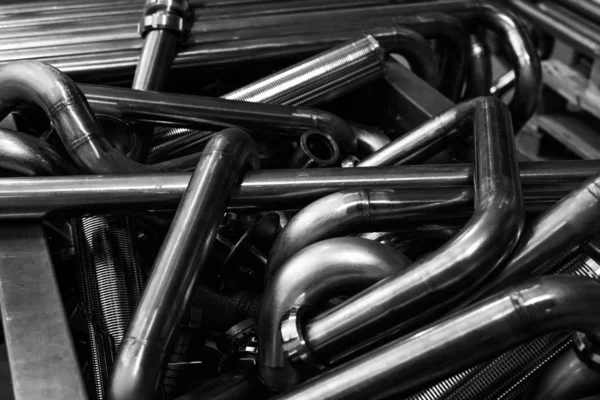 Background of metal twisted pipes. Brilliant clean indirect tubes. black and white photo. Abstract of Pipe bending forming