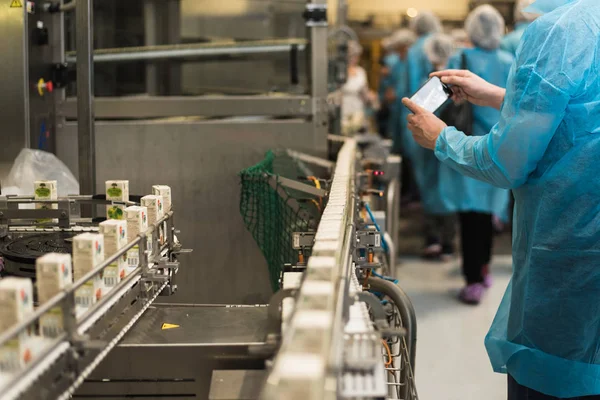 Excursion to the juice factory, packaging and production. a man photographs production