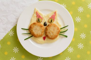 Kedi şeklinde bebek püresi. Patates püresi. Yeşil arka planda çocuk menüsü