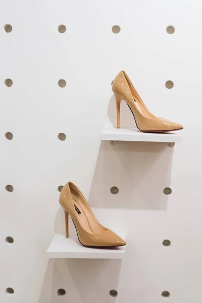 A pair of shoes on the storefront in the store. Strong beige pumps shoes