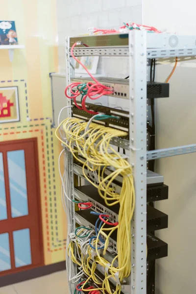 fiber optic in server room close up. Many wires connect to the network interfaces of powerful Internet servers.  Children's server equipment for games.
