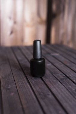 ahşap arka plan üzerinde jel oje siyah şişe. Güzel bir arka plan üzerinde siyah lake