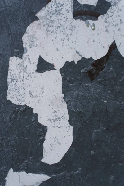 Duvarda boya soyma dikişsiz doku. Rustik koyu gri mavi grunge malzeme deseni. evin duvarında boya soyma. dikey fotoğraf. Yıkılan bir binanın yakın çekim.