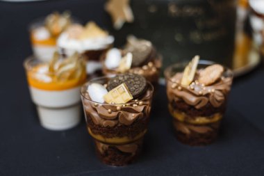 siyah bir arka plan üzerinde kurabiye ile bir bardak çikolatalı kek