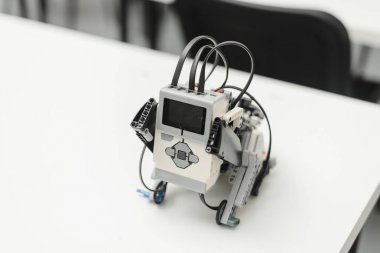 Lego robotu bir alan yörüngesi boyunca sürüyor. Çocuklar bir robot yapmak